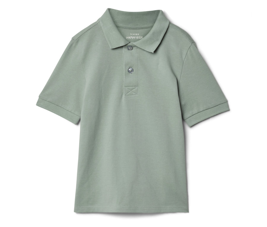 Un polo vert clair pour enfants est posé sur un fond blanc.