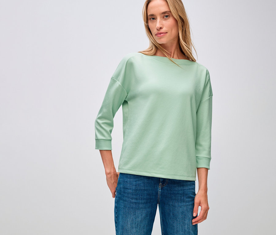 Femme portant un t-shirt avec détails côtelés Street One, vert sauge et un jean.