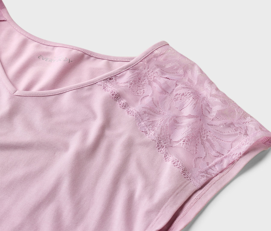 Gros plan d'un t-shirt rose Everyday avec des manches en dentelle sur un fond blanc.