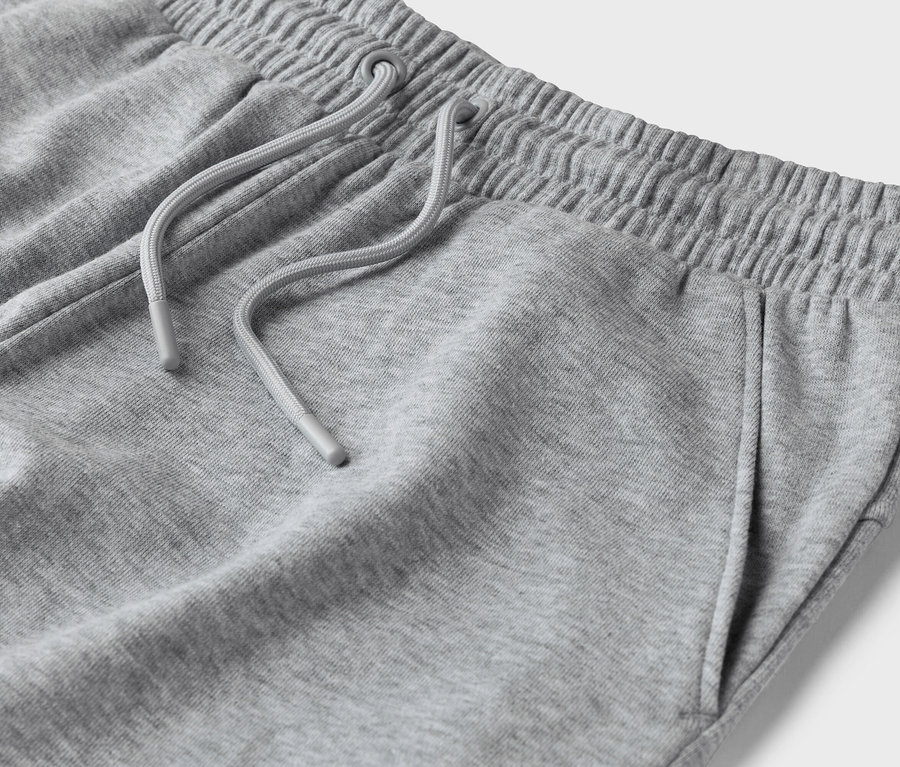 Gros plan d'un pantalon de survêtement gris avec cordon de serrage et poches.