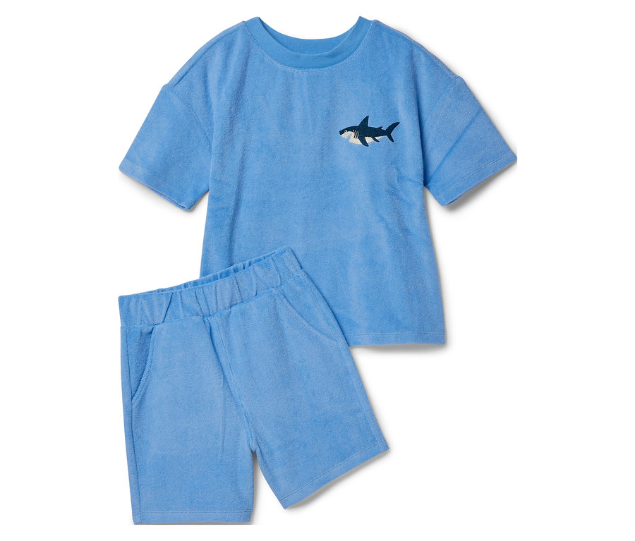 Un ensemble en tissu éponge bleu clair composé d'un t-shirt avec un motif requin et d'un short.