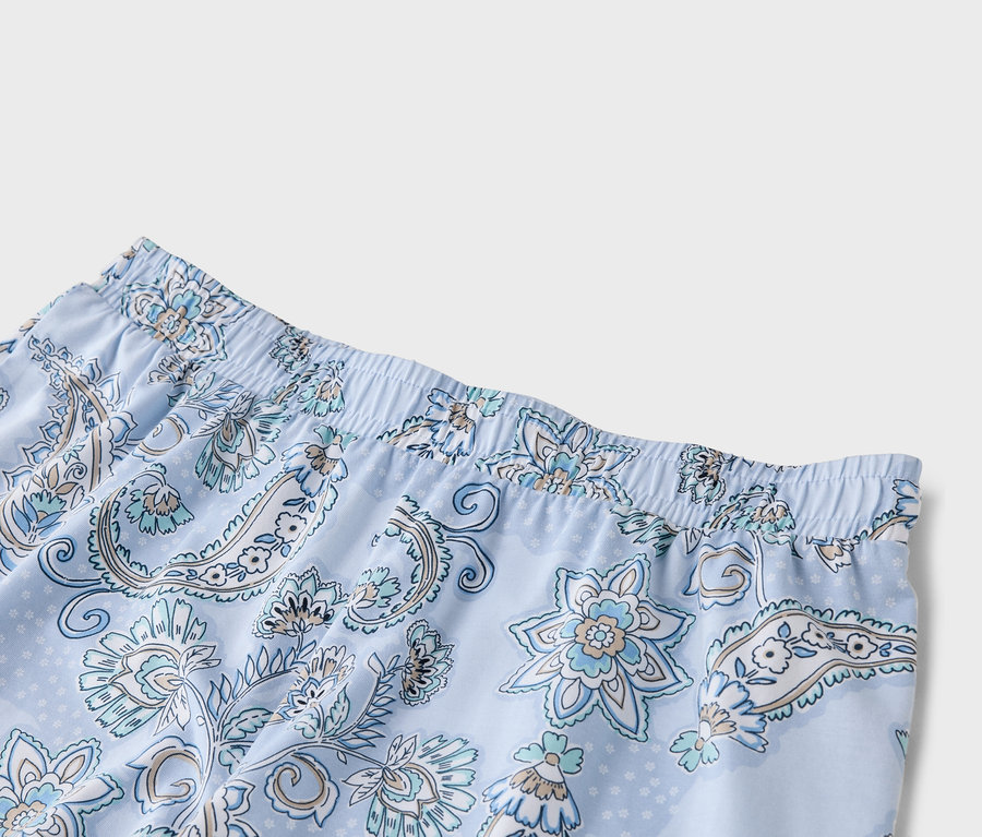 Gros plan d'un pantalon de pyjama bleu clair à motifs floraux avec une taille élastique.
