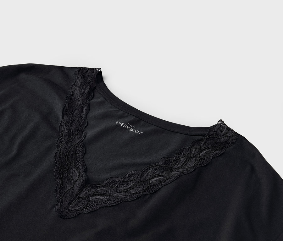 Gros plan sur un t-shirt noir avec une bordure en dentelle sur l'encolure en V.