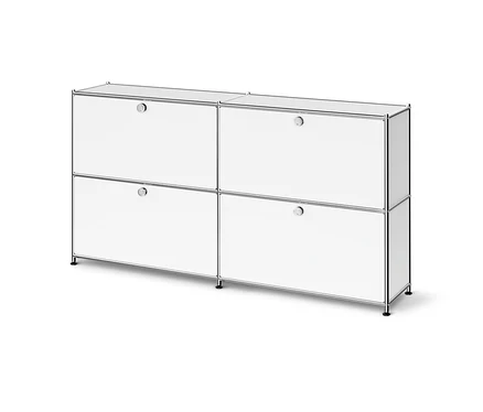 Meuble modulaire blanc avec cadre chromé, comprenant quatre compartiments, chacun avec une porte et une poignée ronde, posé sur de courts pieds noirs.