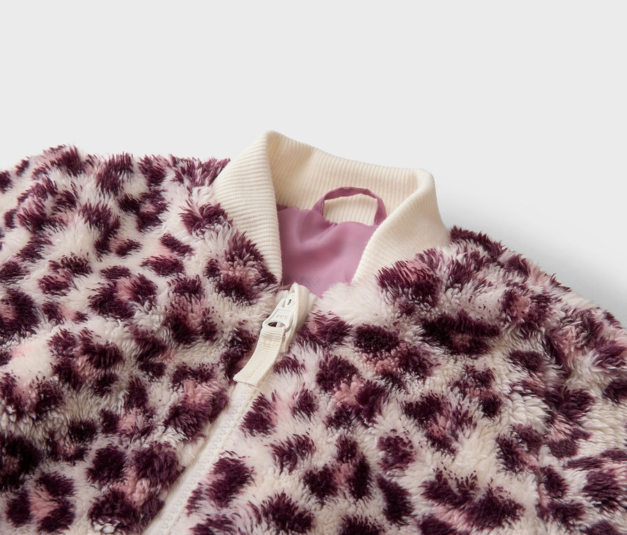 Veste duveteuse à motif léopard violet et blanc, avec col côtelé crème et fermeture éclair.