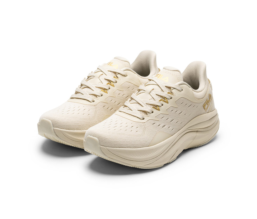 Deux sneakers pour femme FILA Retron de couleur crème avec des accents dorés et des semelles épaisses sur fond blanc.