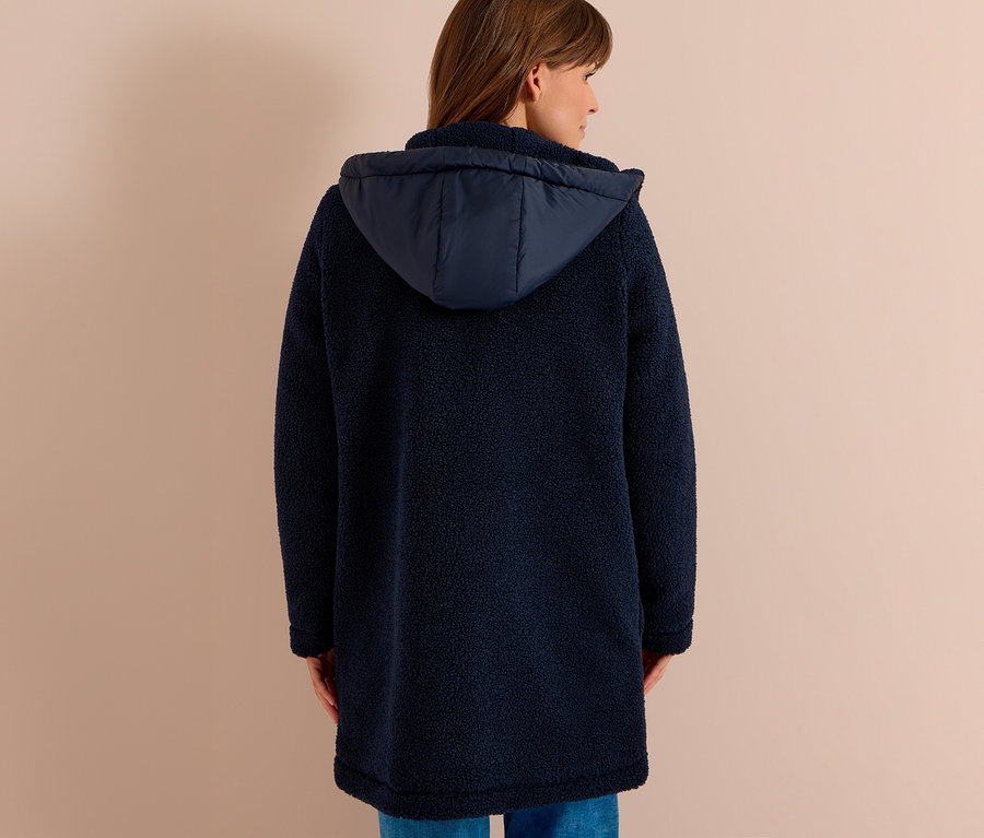Femme de dos portant une longue veste CECIL bleu marine texturée avec une capuche et un jean bleu.