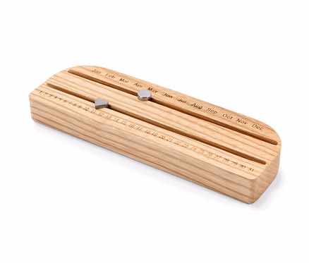 Calendrier éternel en bois avec aimants coulissants indiquant le jour et le mois.