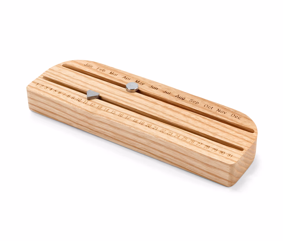 Calendrier éternel en bois avec aimants coulissants indiquant le jour et le mois.