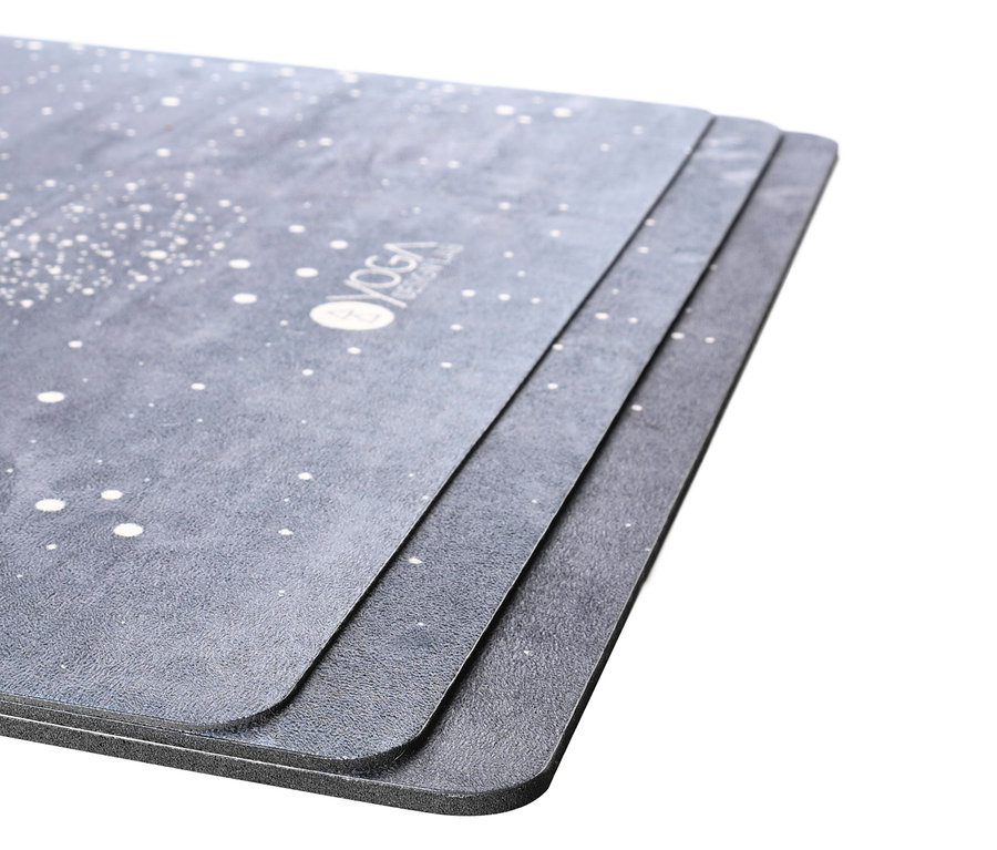 Gros plan de trois tapis de yoga gris avec motif moucheté blanc et logo.