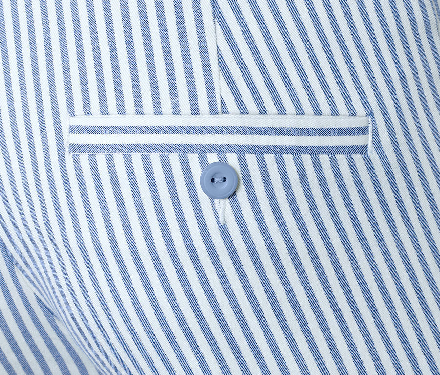 Détail d'un pantalon stretch à rayures avec un bouton.