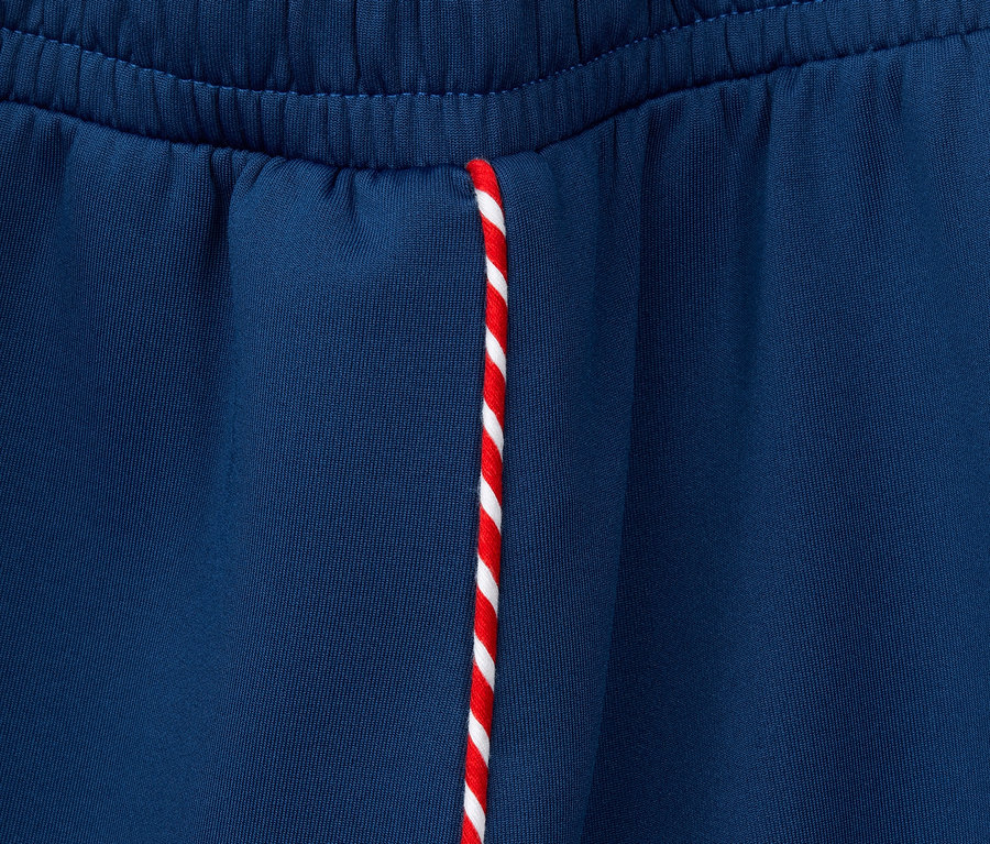 Détail d'une jupe sportive en jersey avec un cordon rouge et blanc.