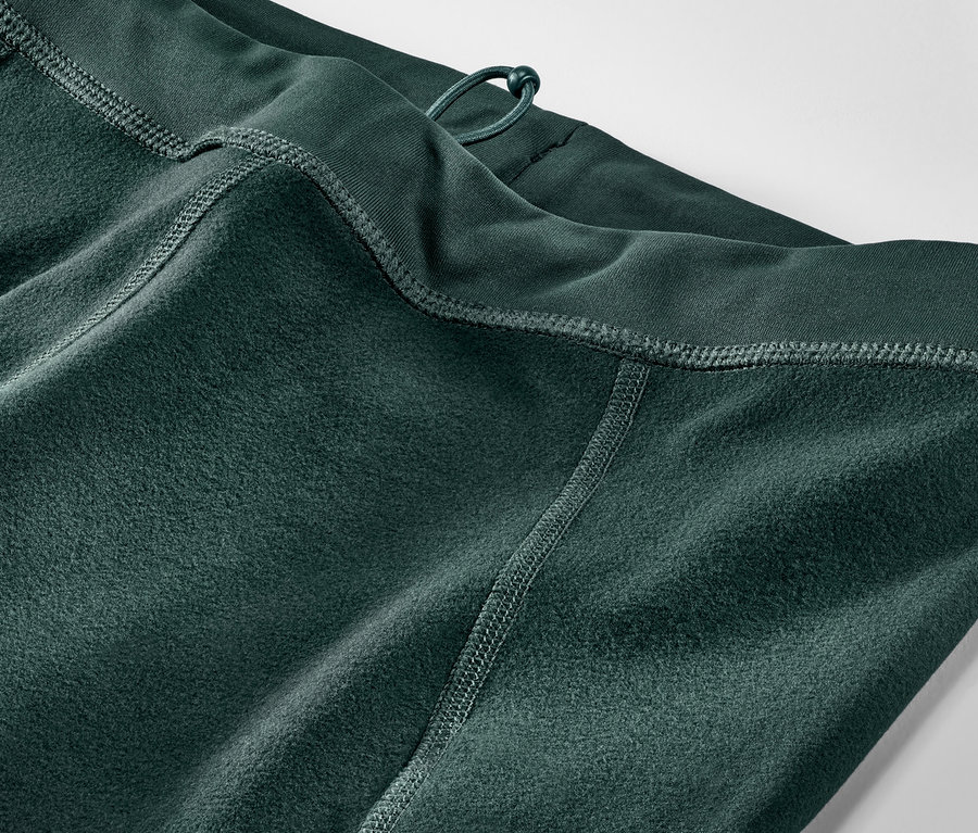 Gros plan sur un legging thermique de course vert foncé.