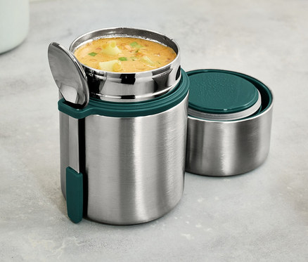 Un récipient isotherme à emporter en acier inoxydable avec de la soupe et une cuillère.