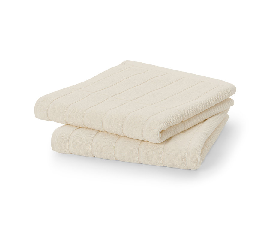 Deux serviettes blanc crème de qualité premium sont empilées.