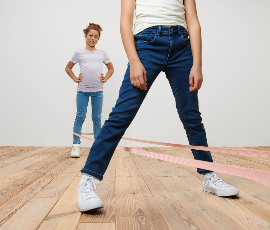 Deux filles jouent au jeu de l’élastique.