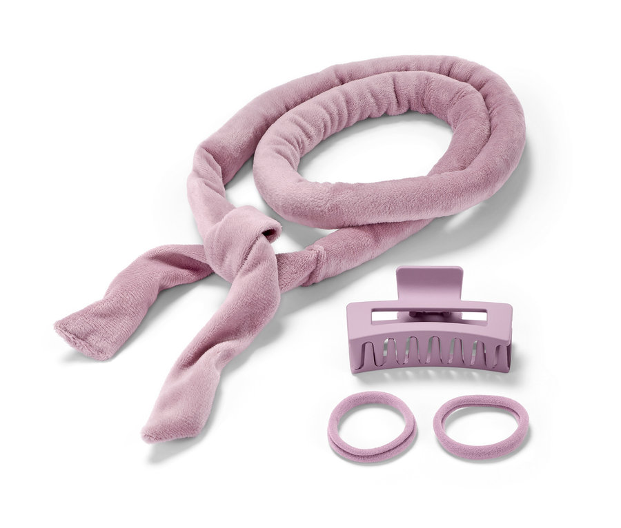 Un bigoudi sans chaleur, une pince à cheveux violette et deux élastiques à cheveux.