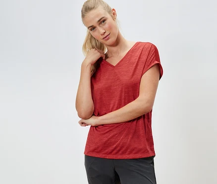 Femme posant dans un t-shirt technique rouge.