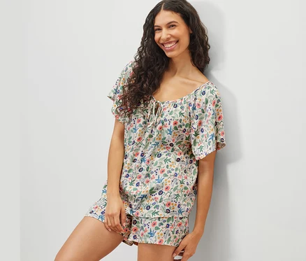 Femme posant dans un ensemble pyjama shorty à motifs floraux.