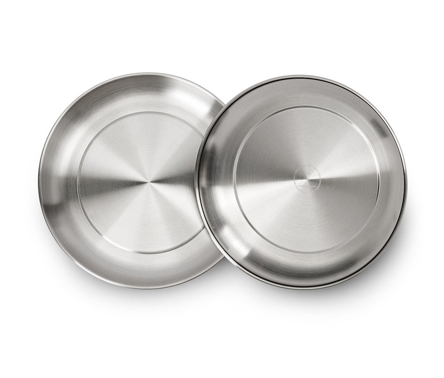 Deux assiettes de camping argentées sont posées sur un fond blanc.