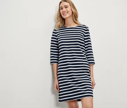 Femme blonde portant une robe molletonnée à rayures.