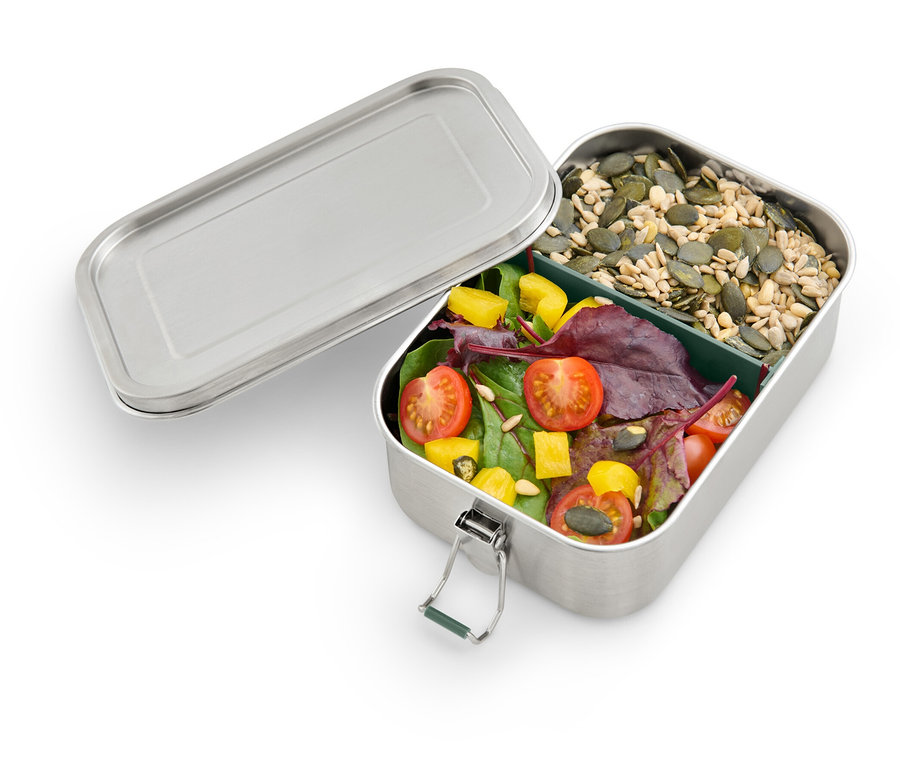 Boîte à lunch ouverte en acier inoxydable avec compartiment. Une section contient de la salade et l'autre des graines de courge.