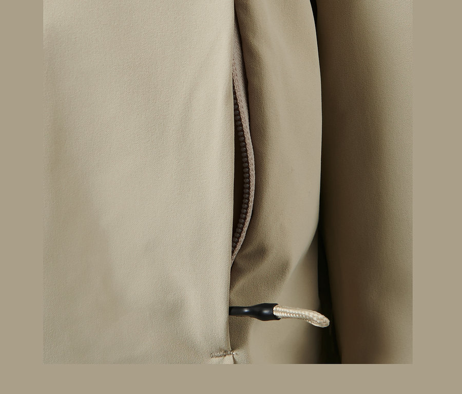 Gros plan sur un manteau d'extérieur 3 en 1 gris avec fermeture éclair et cordon de serrage.