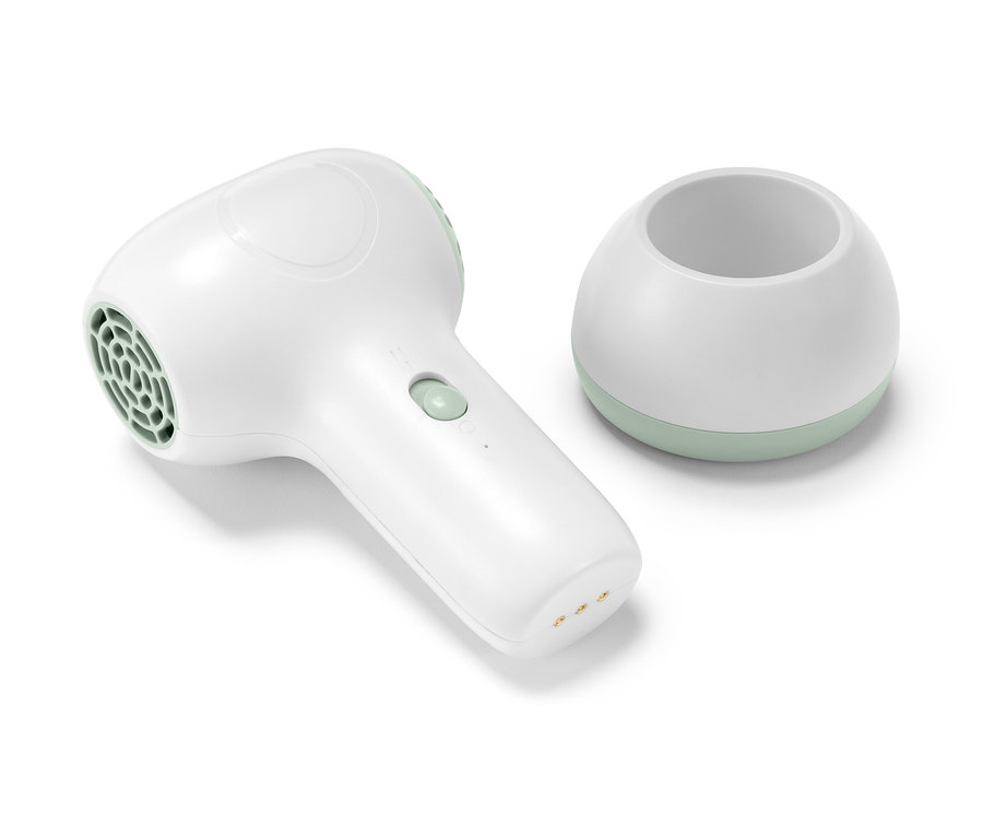 Un sèche-cheveux pour bébé blanc à batterie et son support blanc avec une bordure vert menthe.