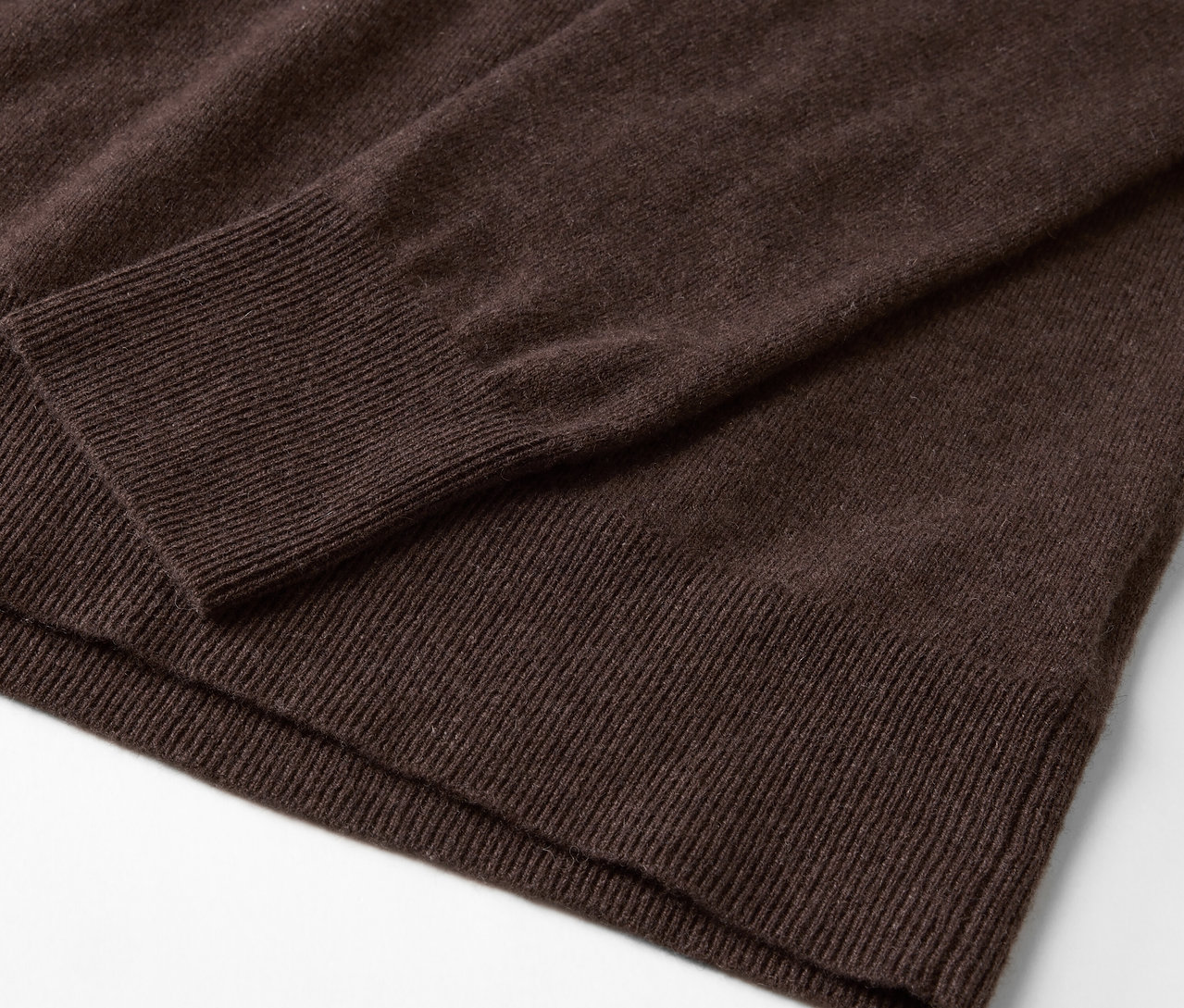 Gros plan sur un pull marron à manches longues.