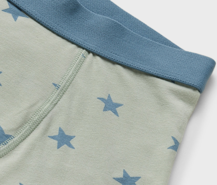 Vue détaillée d'un caleçon boxeur vert clair avec des étoiles bleues et une ceinture bleue.