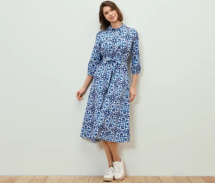 Femme posant dans une robe mi-longue imprimée.