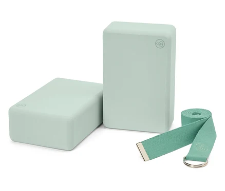 Deux blocs de yoga vert clair et une sangle assortie.