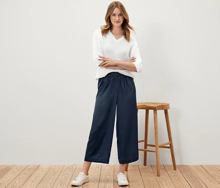 Femme posant en pantalon satiné bleu marine.