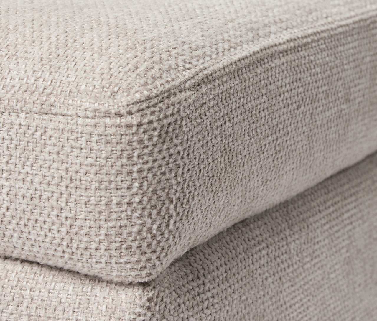 Gros plan d'un pouf beige.