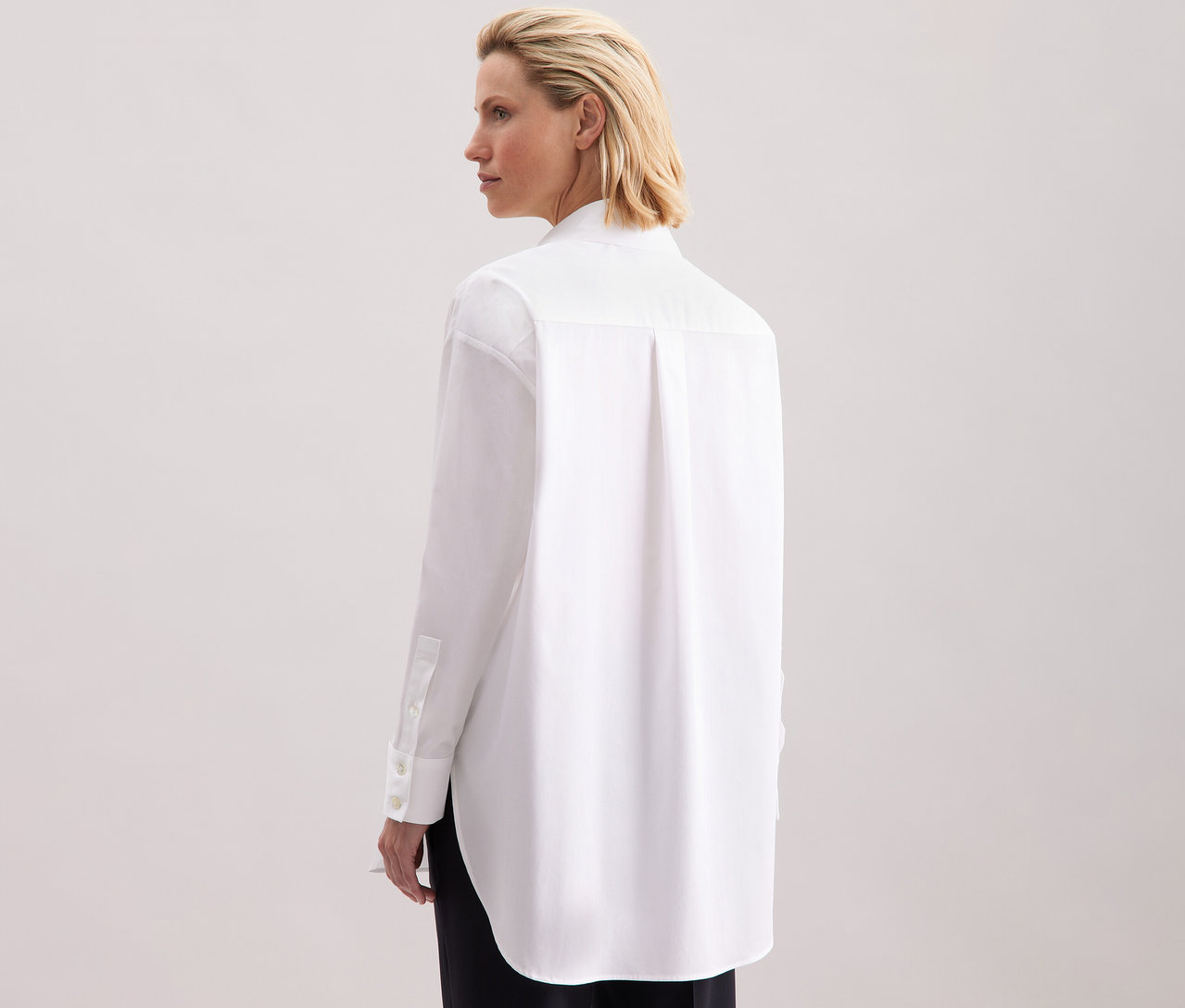 Femme vue de dos portant une blouse-chemise grande taille blanche Seidensticker.