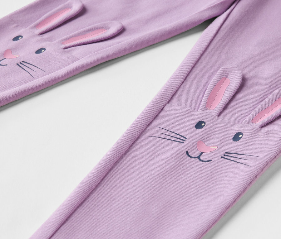 Gros plan sur un legging lavande avec un visage de lapin et des oreilles en 3D.