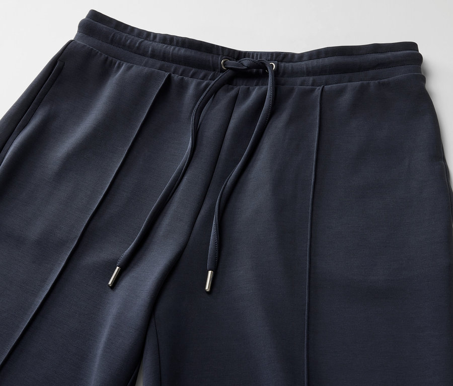 Détail d'un pantalon de jogging bleu marine en mélange modal avec cordon de serrage.