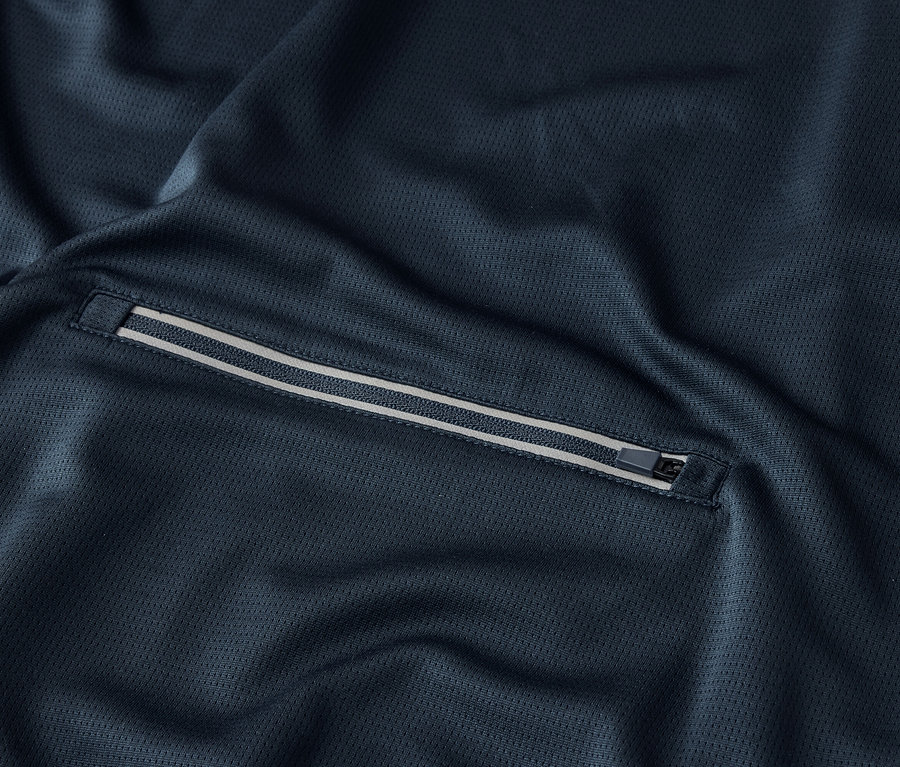 Gros plan sur un tissu bleu marine avec une poche zippée.
