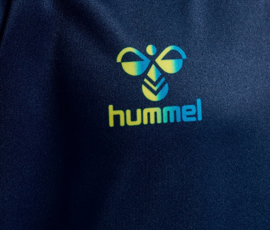 Gros plan d'un tissu bleu marine avec le logo Hummel en jaune et turquoise.