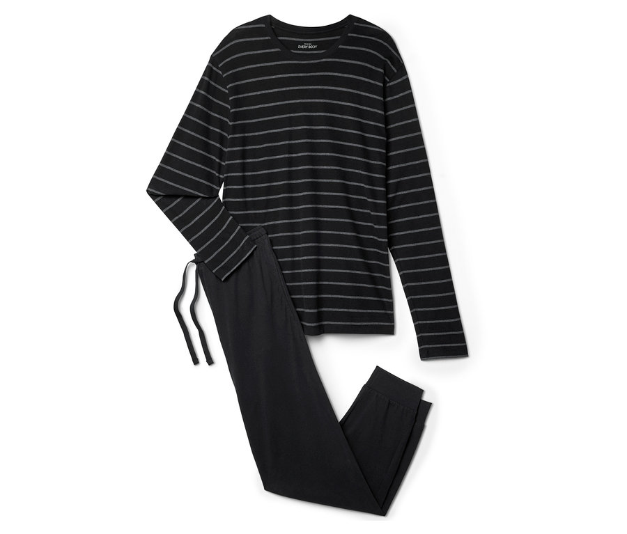 Un pyjama noir rayé est posé sur un fond blanc.
