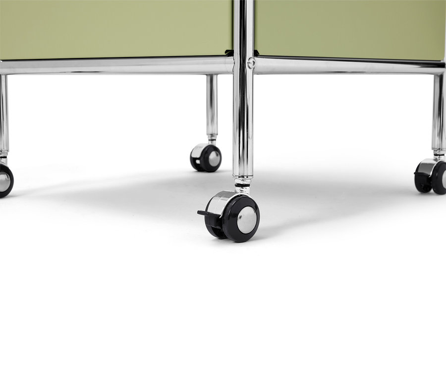Gros plan d'un rayonnage mobile vert clair avec des pieds chromés sur fond blanc.