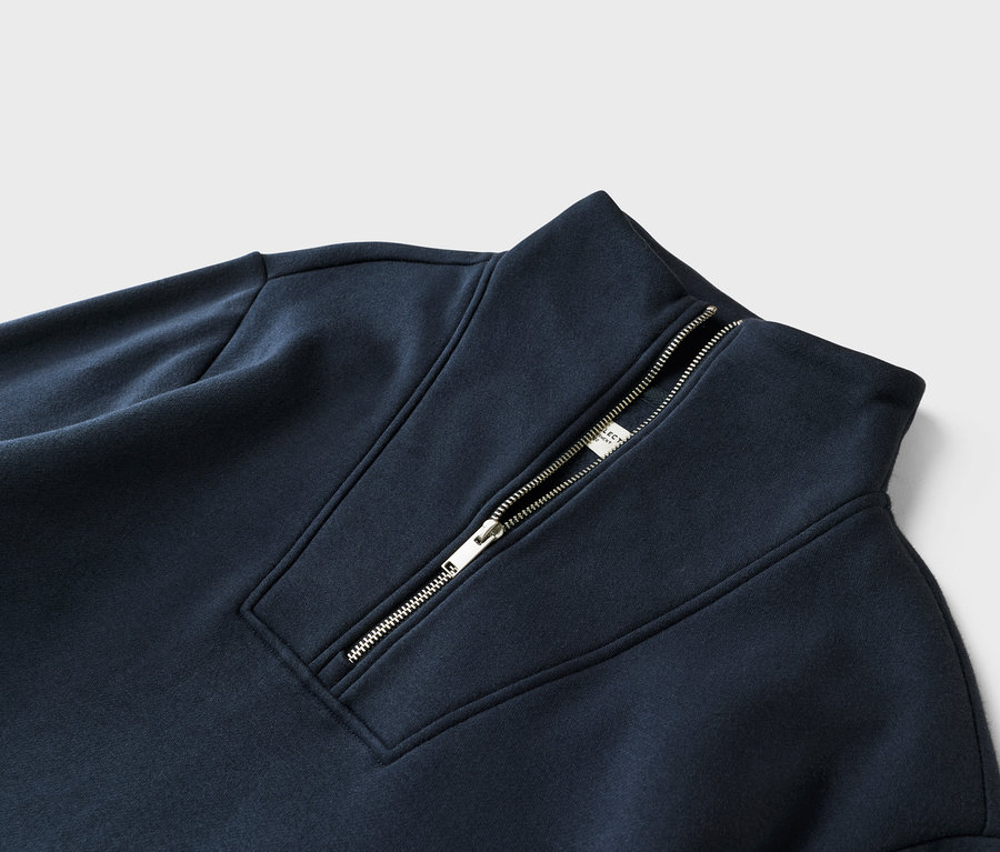 Gros plan d'un sweat-shirt bleu marine avec fermeture éclair au niveau du col.