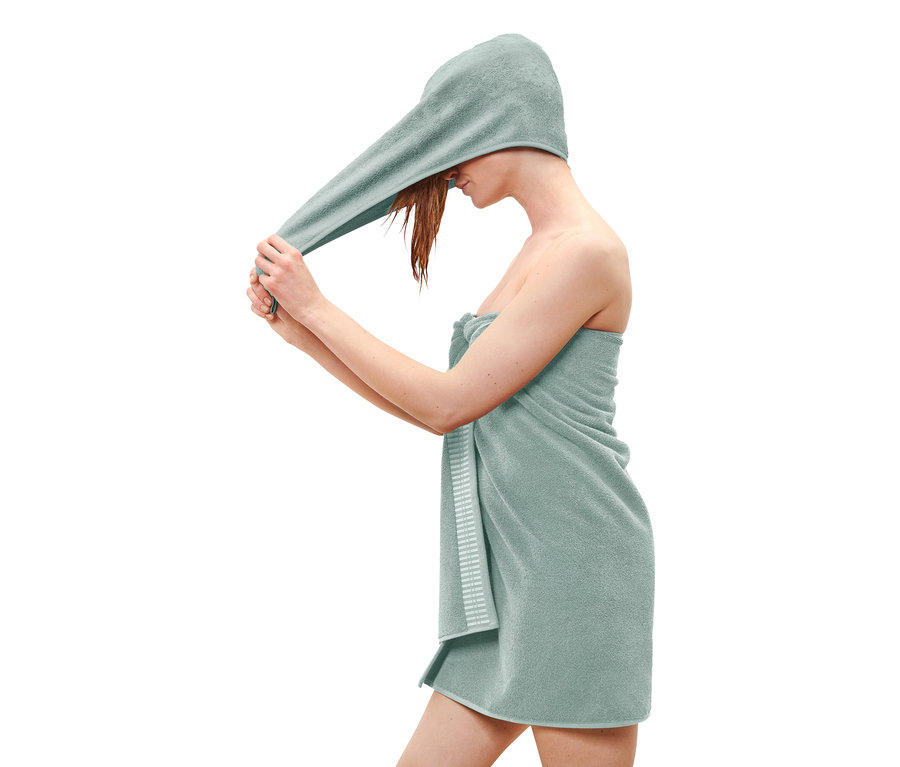 Femme séchant ses cheveux avec une serviette bleu clair.