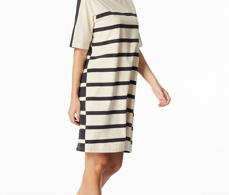 Une femme porte une robe t-shirt rayée à manches courtes en noir et crème.