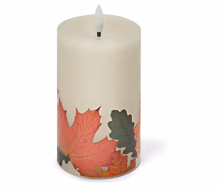 Une bougie LED cylindrique crème avec un décor de feuilles d'automne sur un fond blanc.