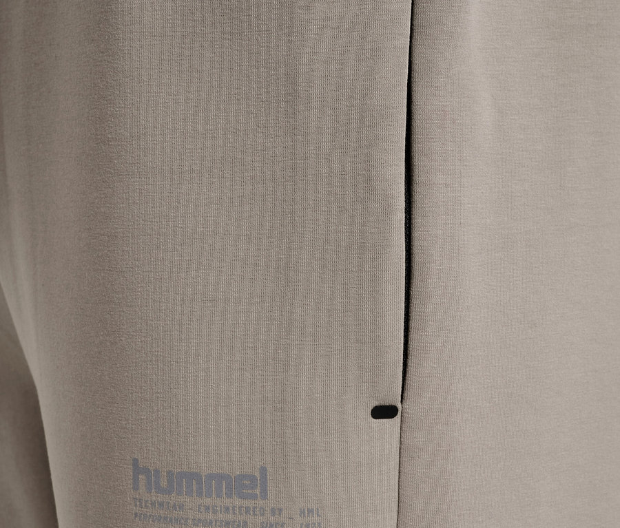 Gros plan sur un pantalon de jogging beige avec le logo Hummel.