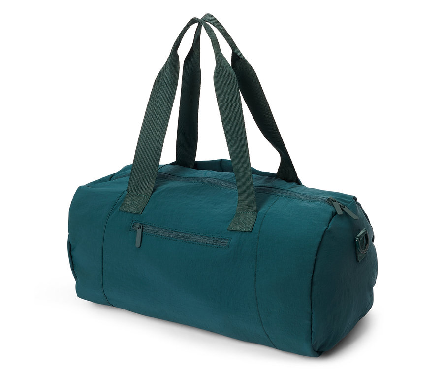 Un sac de sport vert foncé avec des fermetures éclair et des poignées est posé sur une surface blanche.