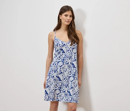 Femme portant une robe d'été bleue et blanche sans manches.