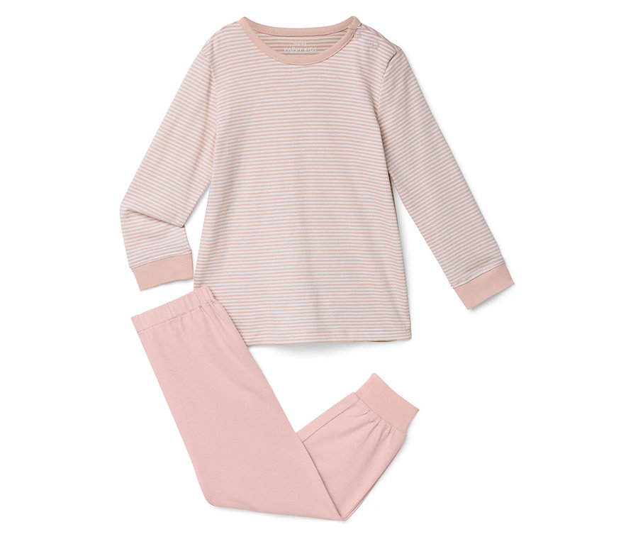 Un haut de pyjama rayé à manches longues et un pantalon de pyjama rose uni sont posés sur un fond blanc.