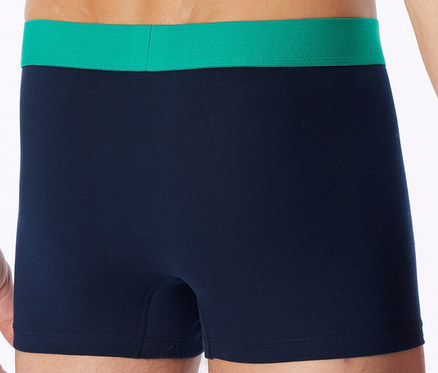 Personne portant un boxer bleu marine avec une ceinture vert vif.